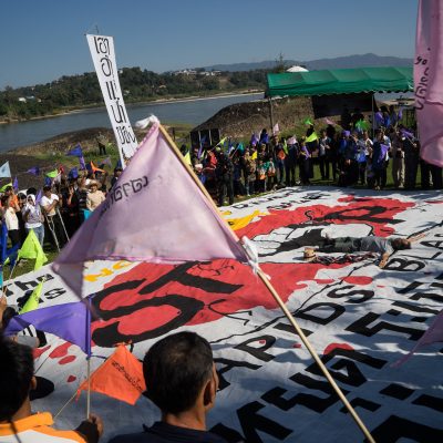 Participants in a protest performance surround a banner that says “The Mekong River is not for Sale: Stop the Mekong Rapid Blasting Project.” Mister Tong Phun, Thai poet and writer, lies in the middle. The social movements of local and environmental activists who are protecting the Mekong River is often linked to arts and literature.