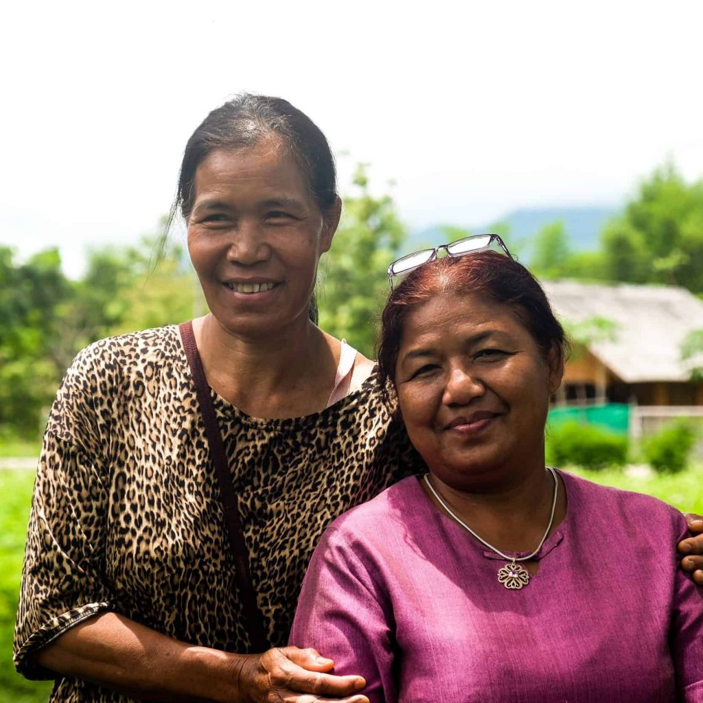 A woman from Nan and a woman from Mae Moh pose after connecting around their shared stories of facing pollution and threats to their local environments.