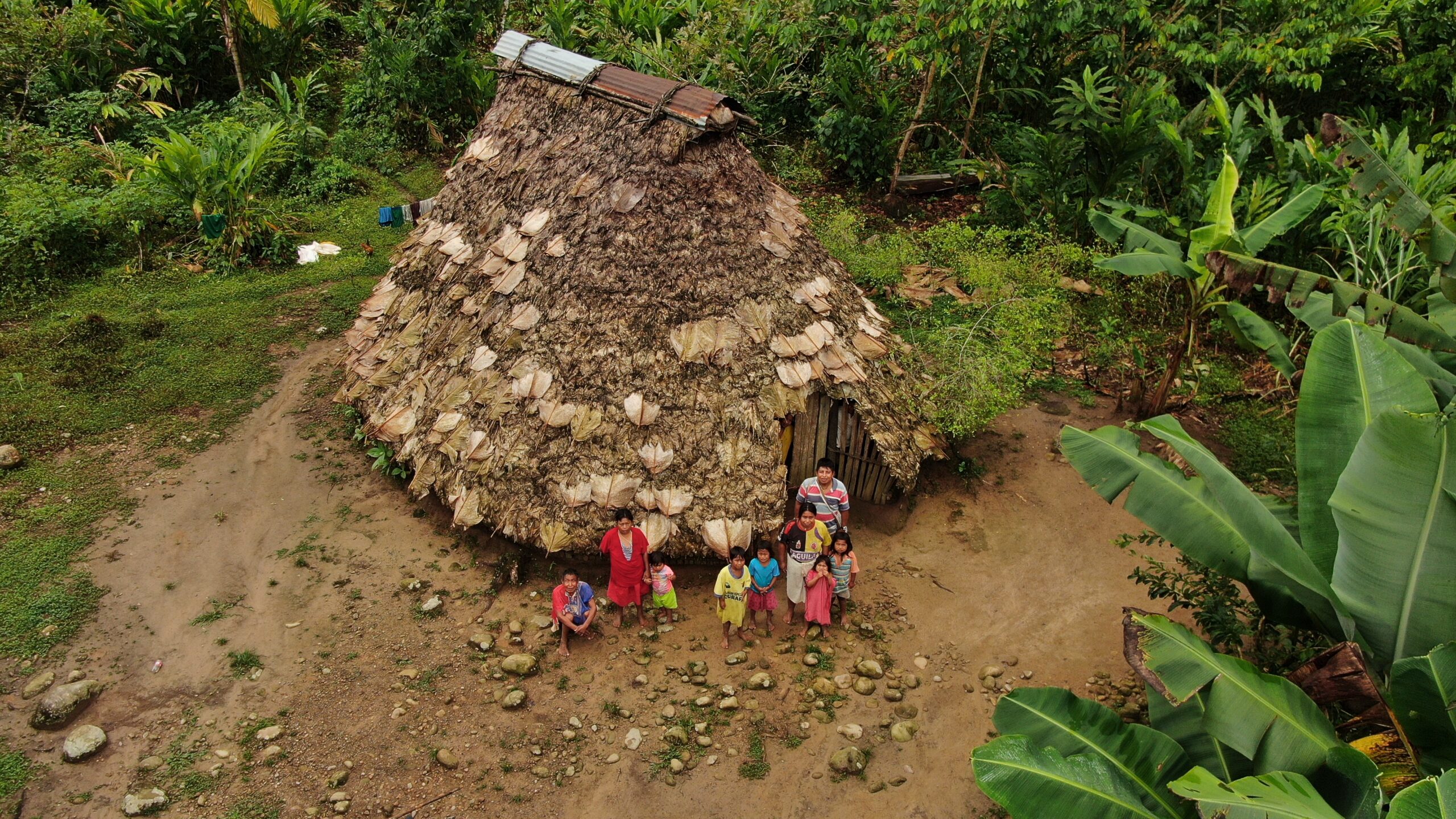 people outside their thatched roof shown from above