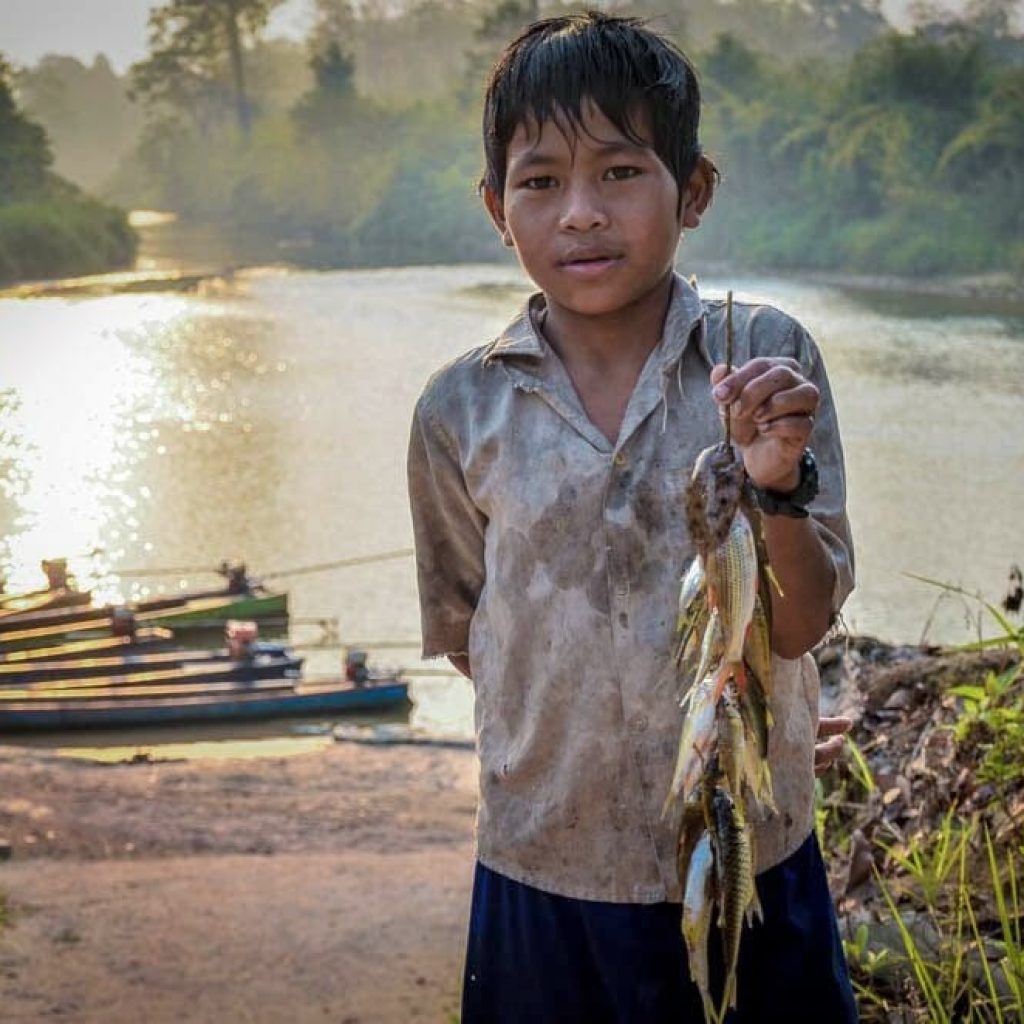 A young Mondul Yorn villager shows the fish that he caught.