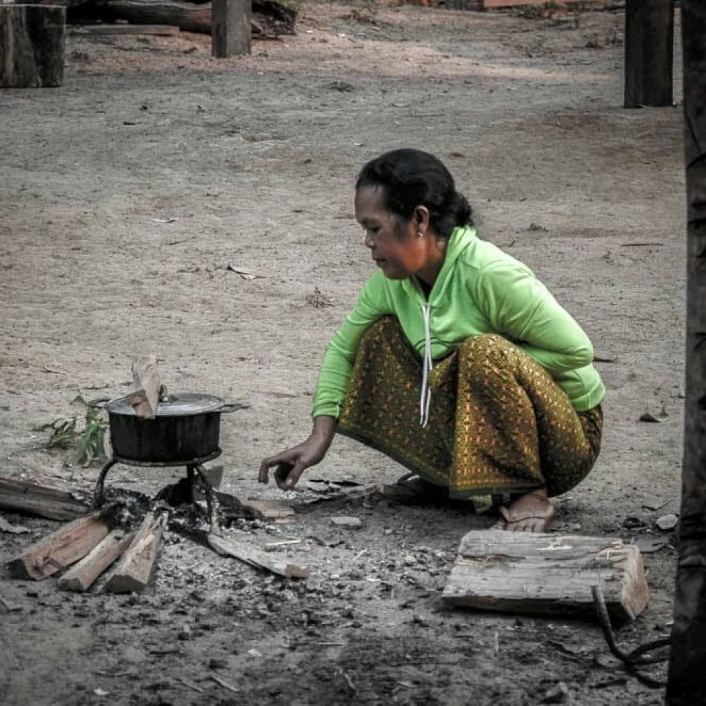 A villager cooks fish for dinner.