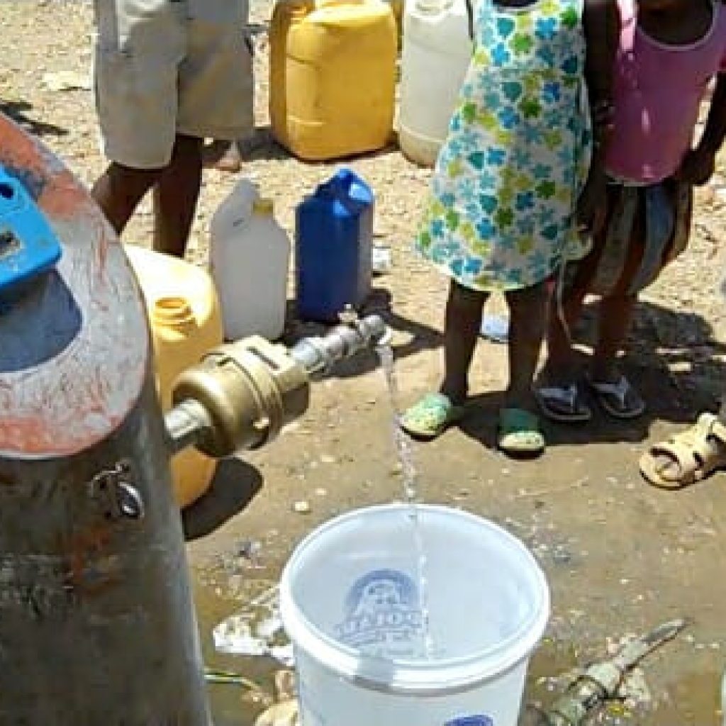 Namibian children wait in line at a water meter
